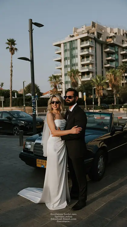 שמלת כלה סטרפלס בגזרה נקייה וישרה עם שובל קליל, עשויה בד סאטן חלק ונופל. מראה אלגנטי ומודרני עם הינומה מינימליסטית.